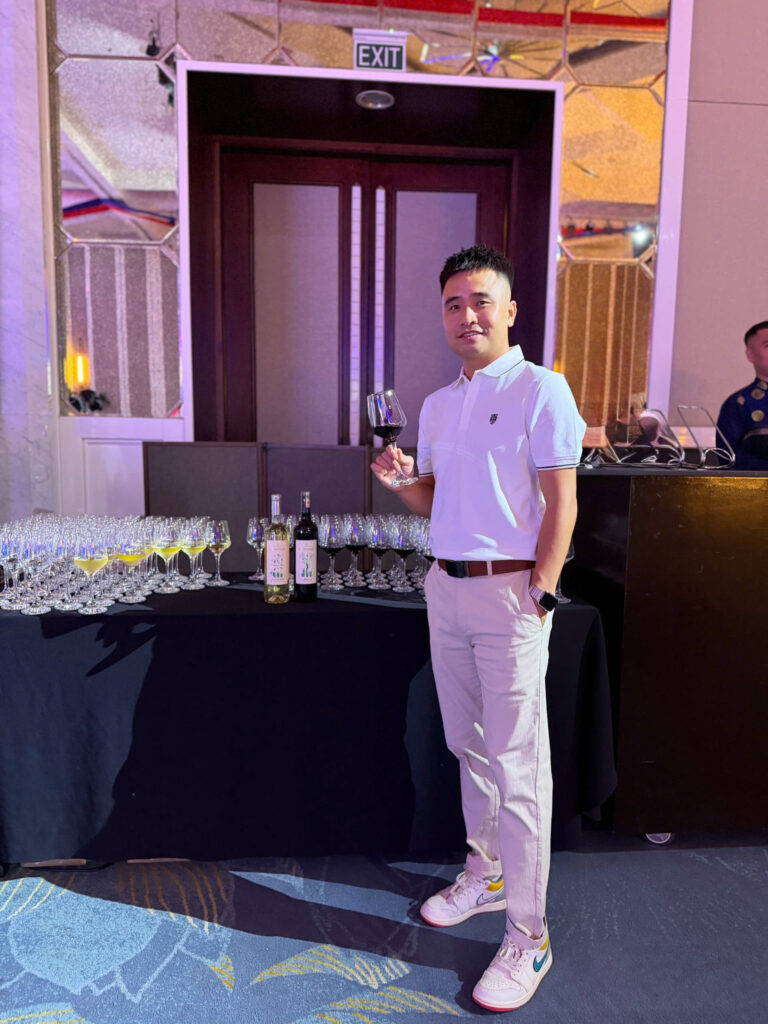Khách tham dự cầm ly vang bên bàn phục vụ Chateau Dalat Heritage tại Meliá Hà Nội.